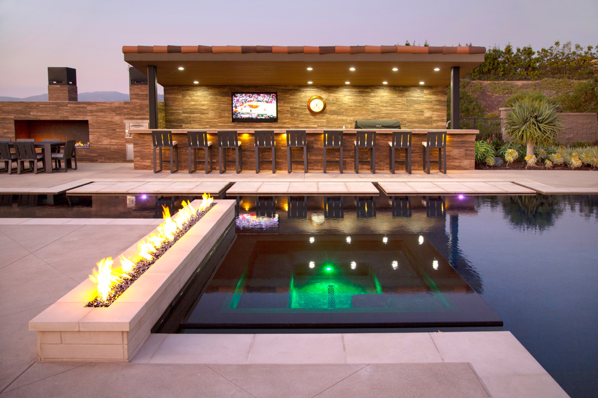 Integrated spa with fire pit and poolside outdoor bar