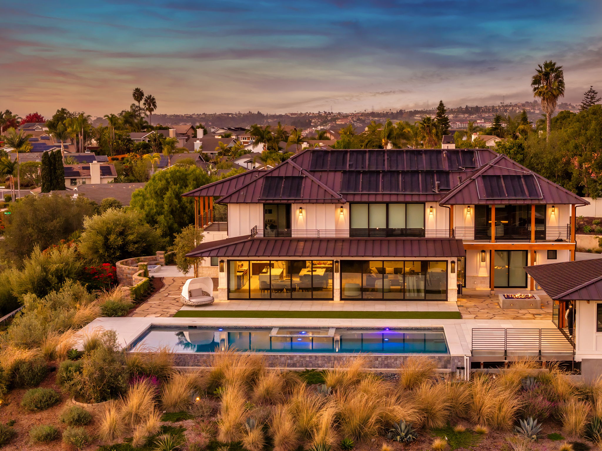 Luxury home with renovated pool and landscaped hillside at twilight