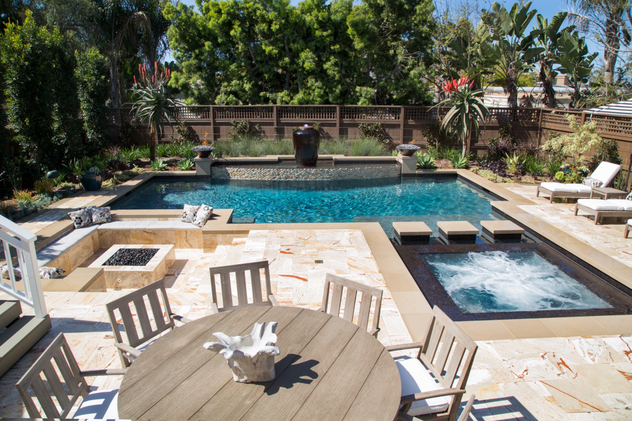Renovated pool with spa, fire pit, and raised waterfall feature