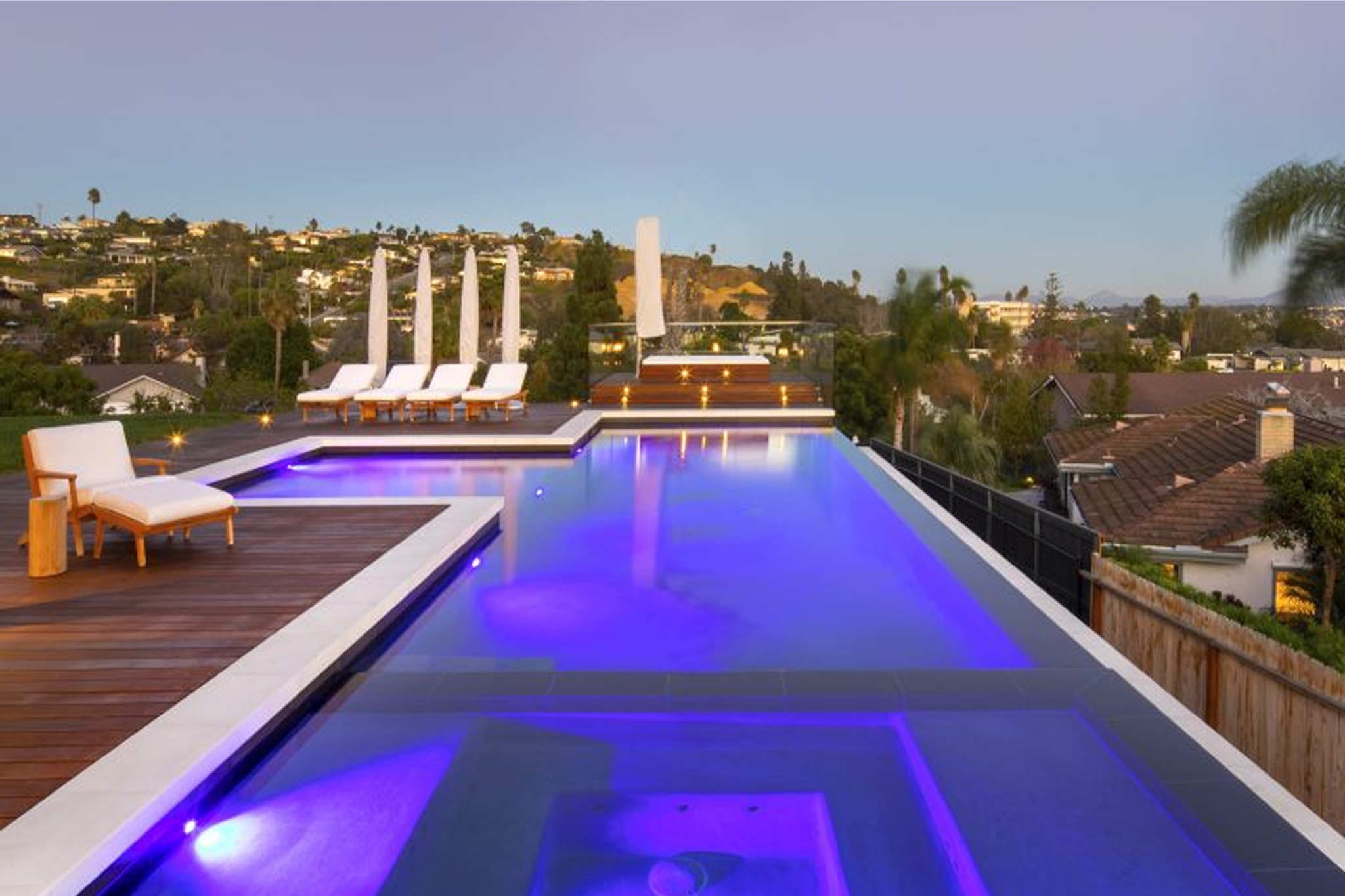 A luxury swimming pool aerial shot that's illuminated in purple light