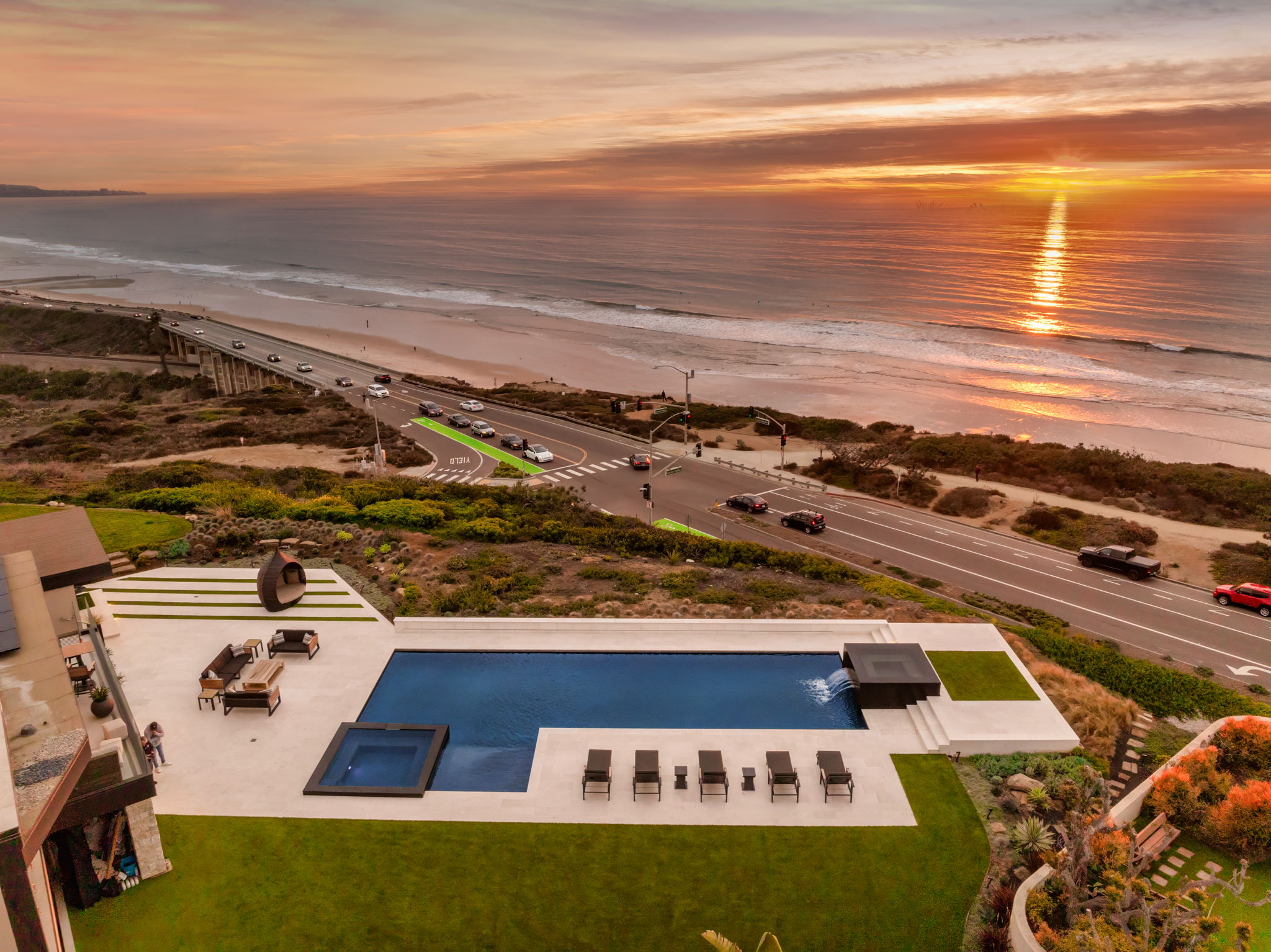 Modern luxury pool and spa with oceanfront sunset view
