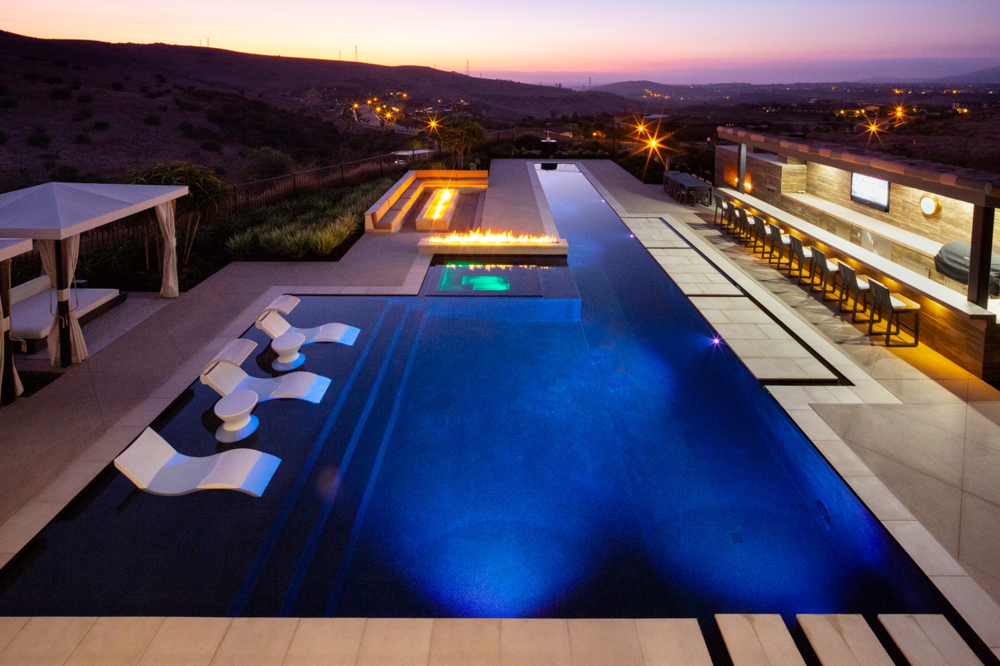 Geometric pool and spa with natural stone coping and pergola