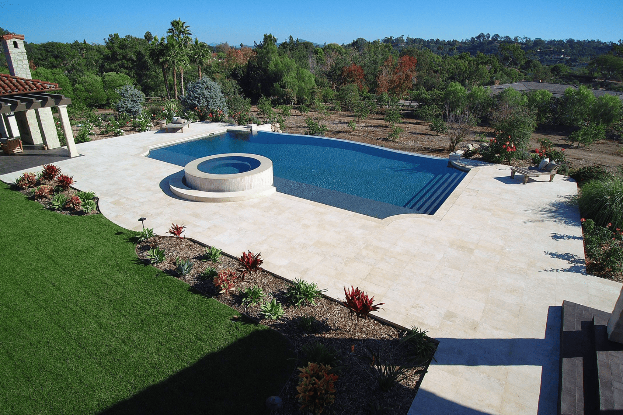 An aerial shot of a luxury pool with a circular water feature