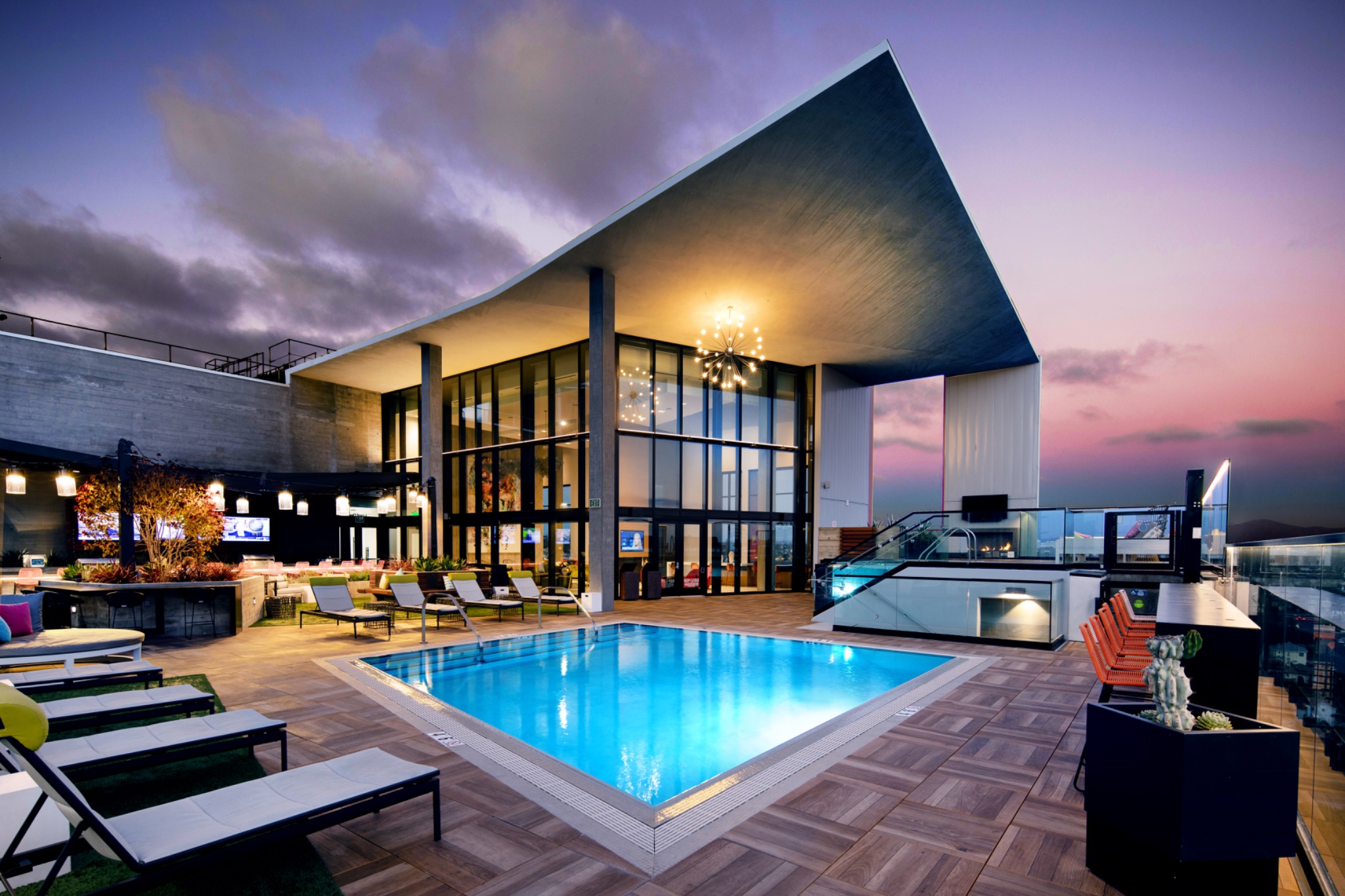 Rooftop commercial pool with lounge deck at twilight