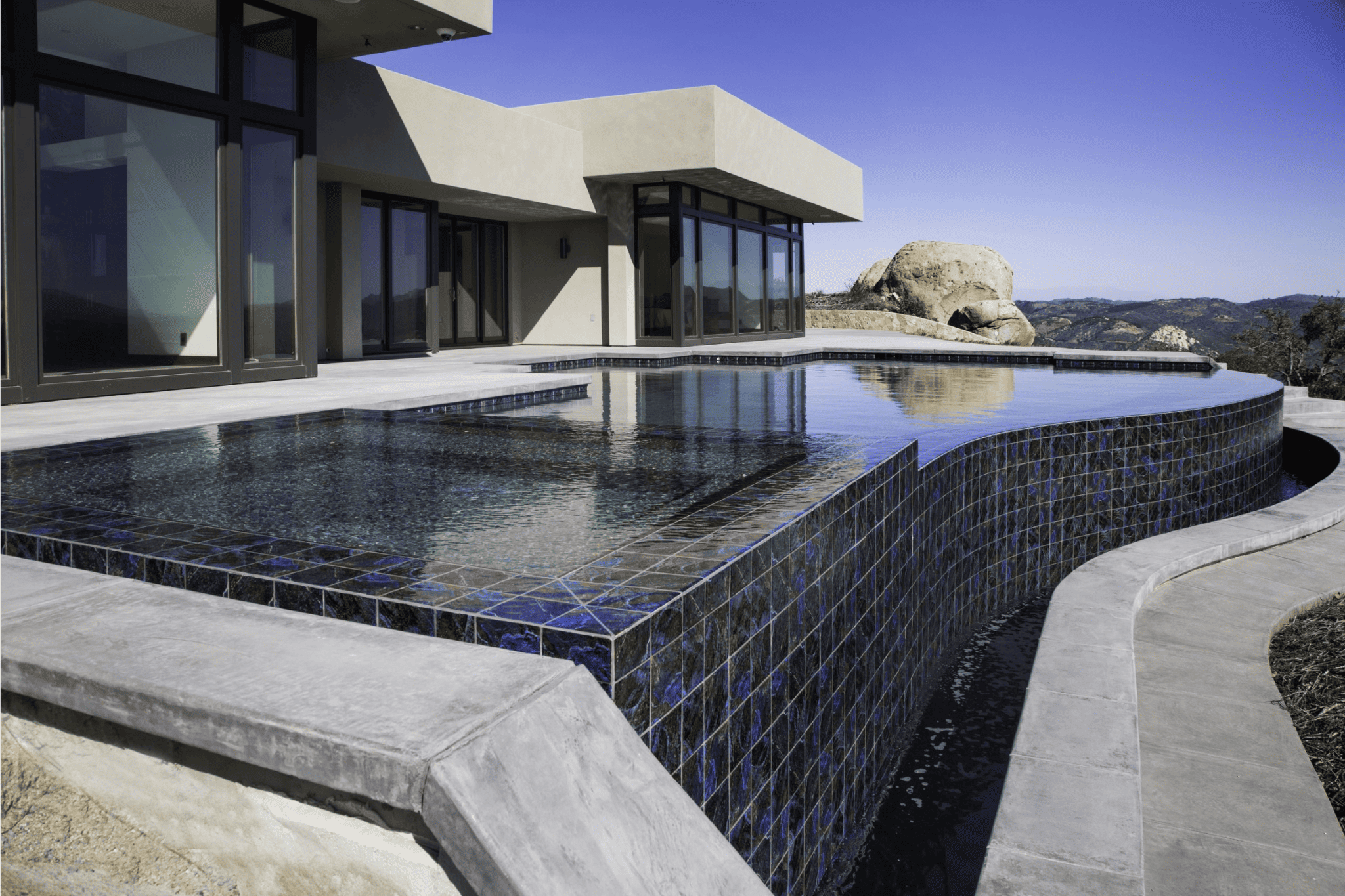 A luxury pool with brickwork cliffing into a trench