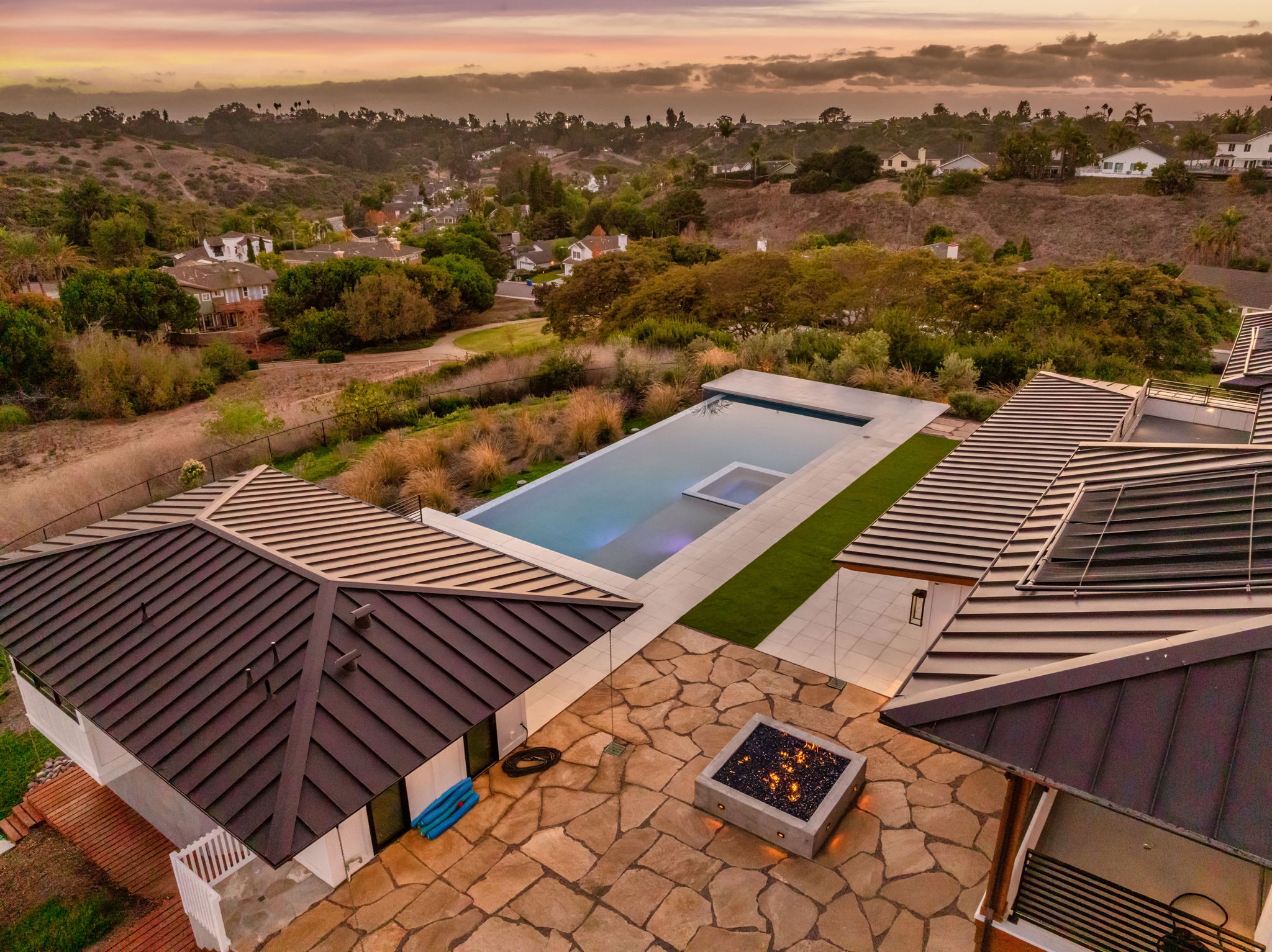 Aerial view of modern lap pool with integrated spa on hillside lot