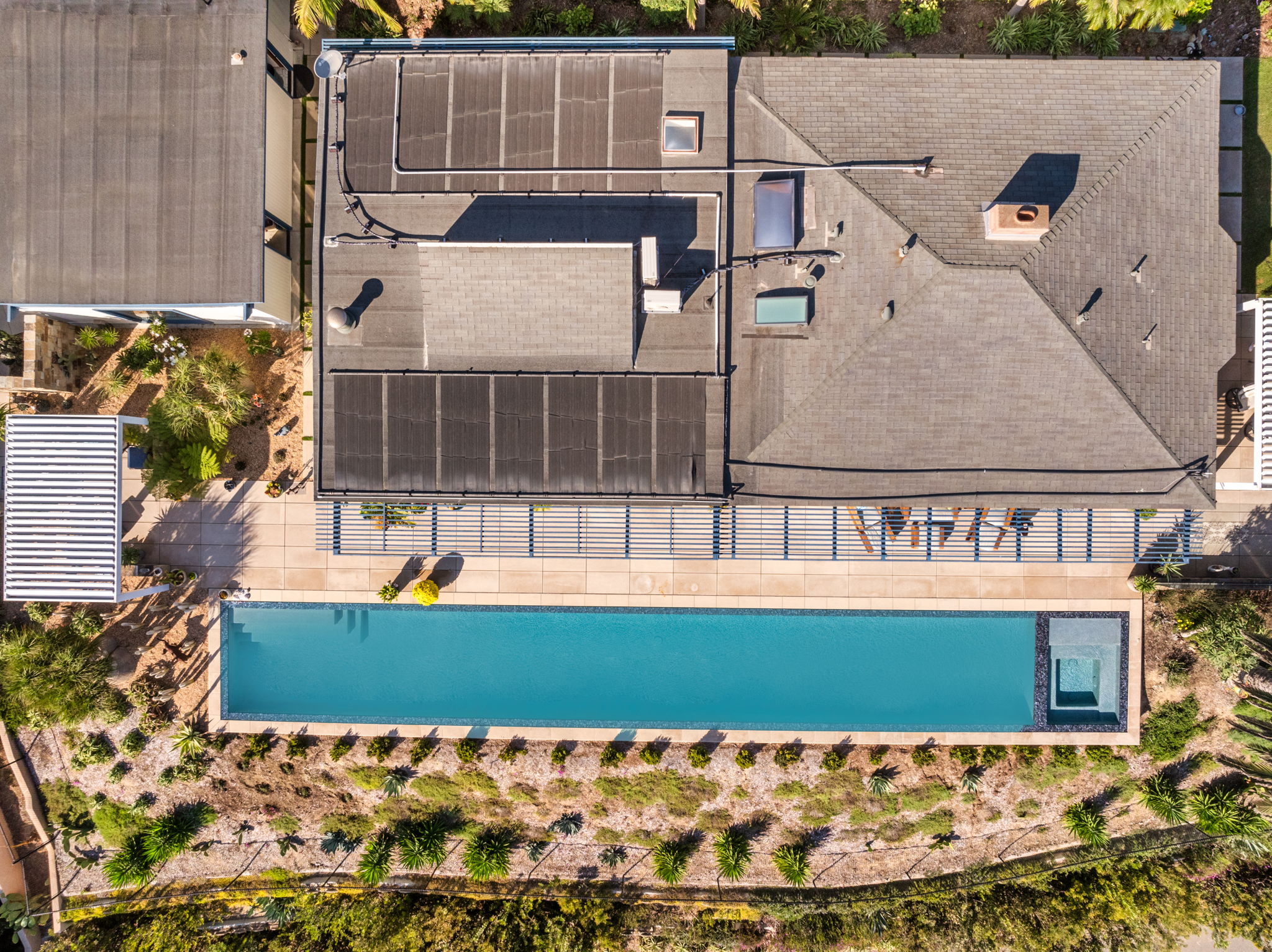 Aerial view of lap pool with solar heating panels on roof