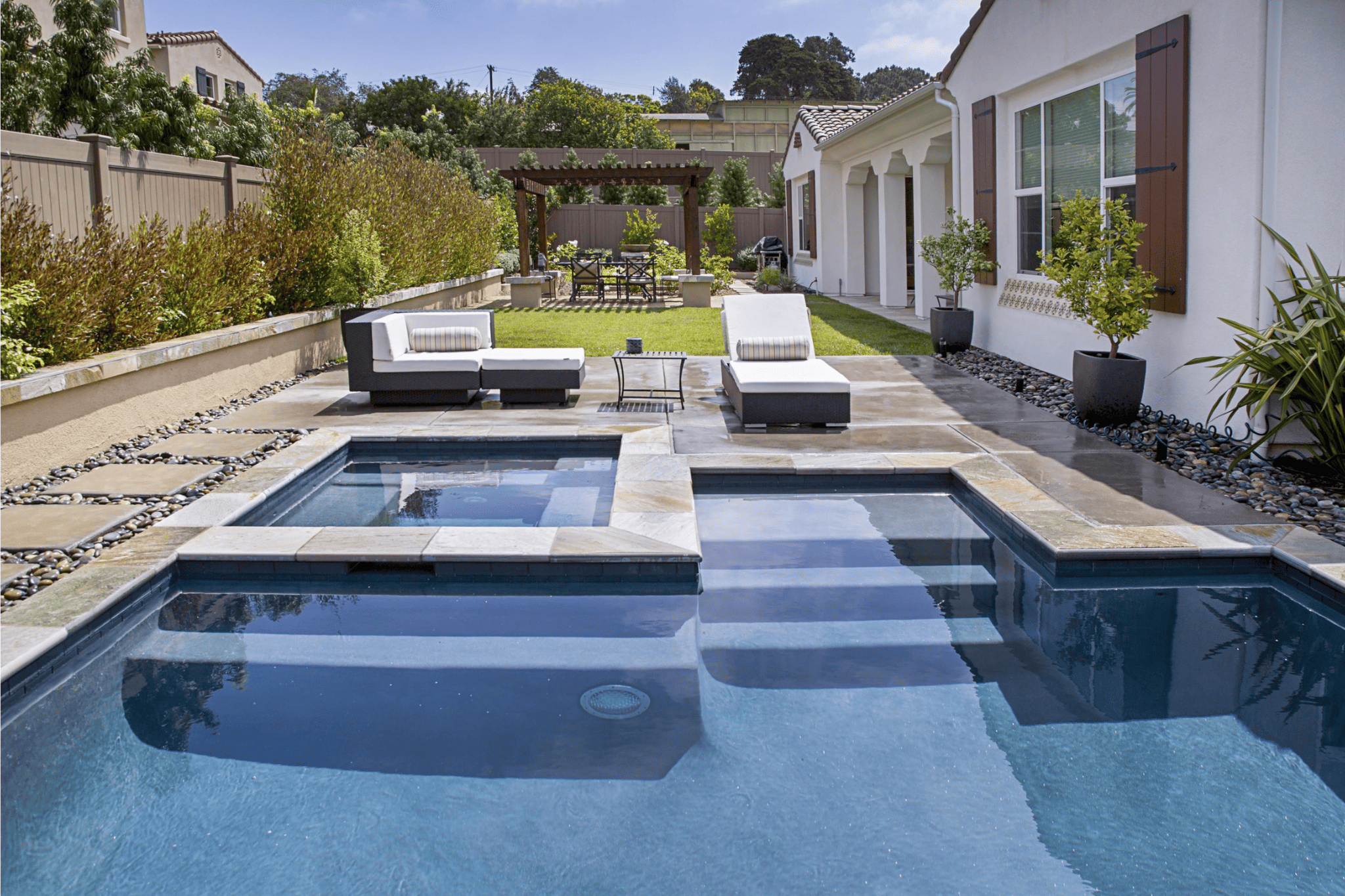 A luxury pool with deck chairs nearby