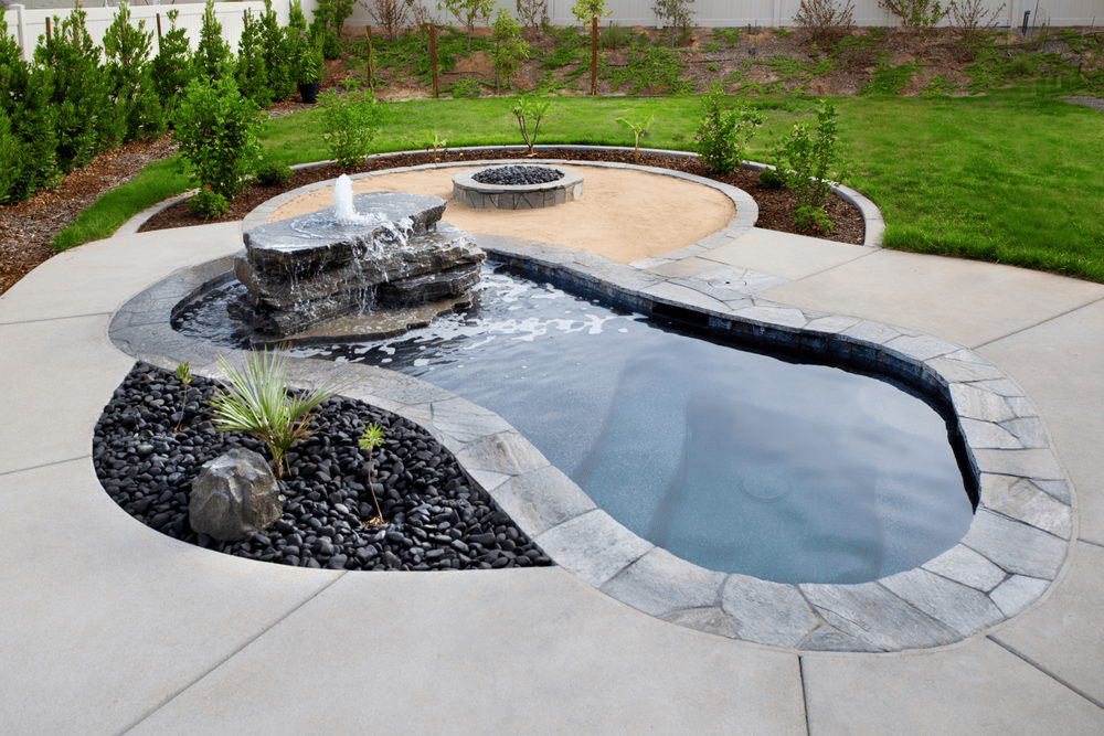 Backyard pool with raised stone spa and hillside view.