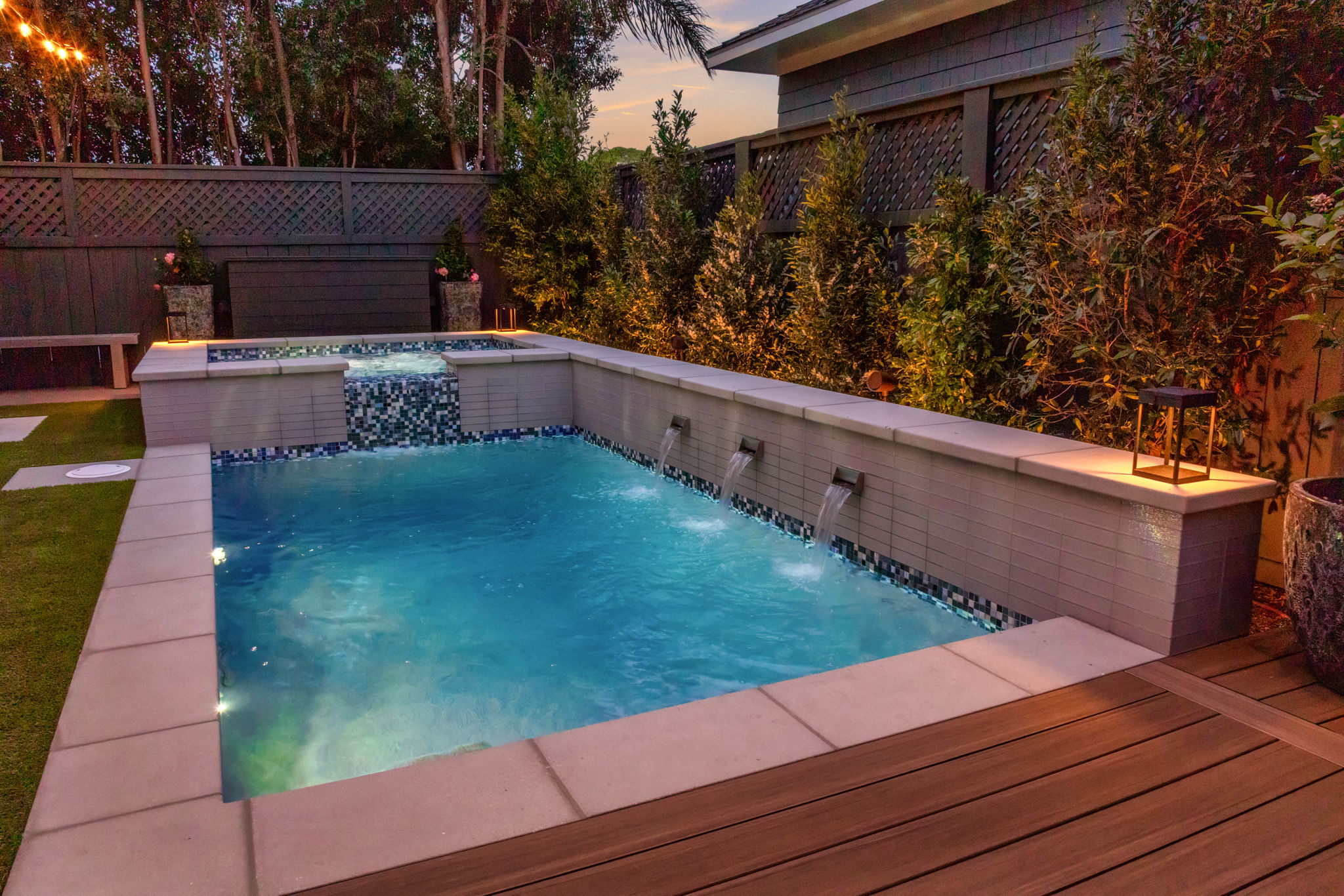 Raised luxury pool with sheer descent water features and tile