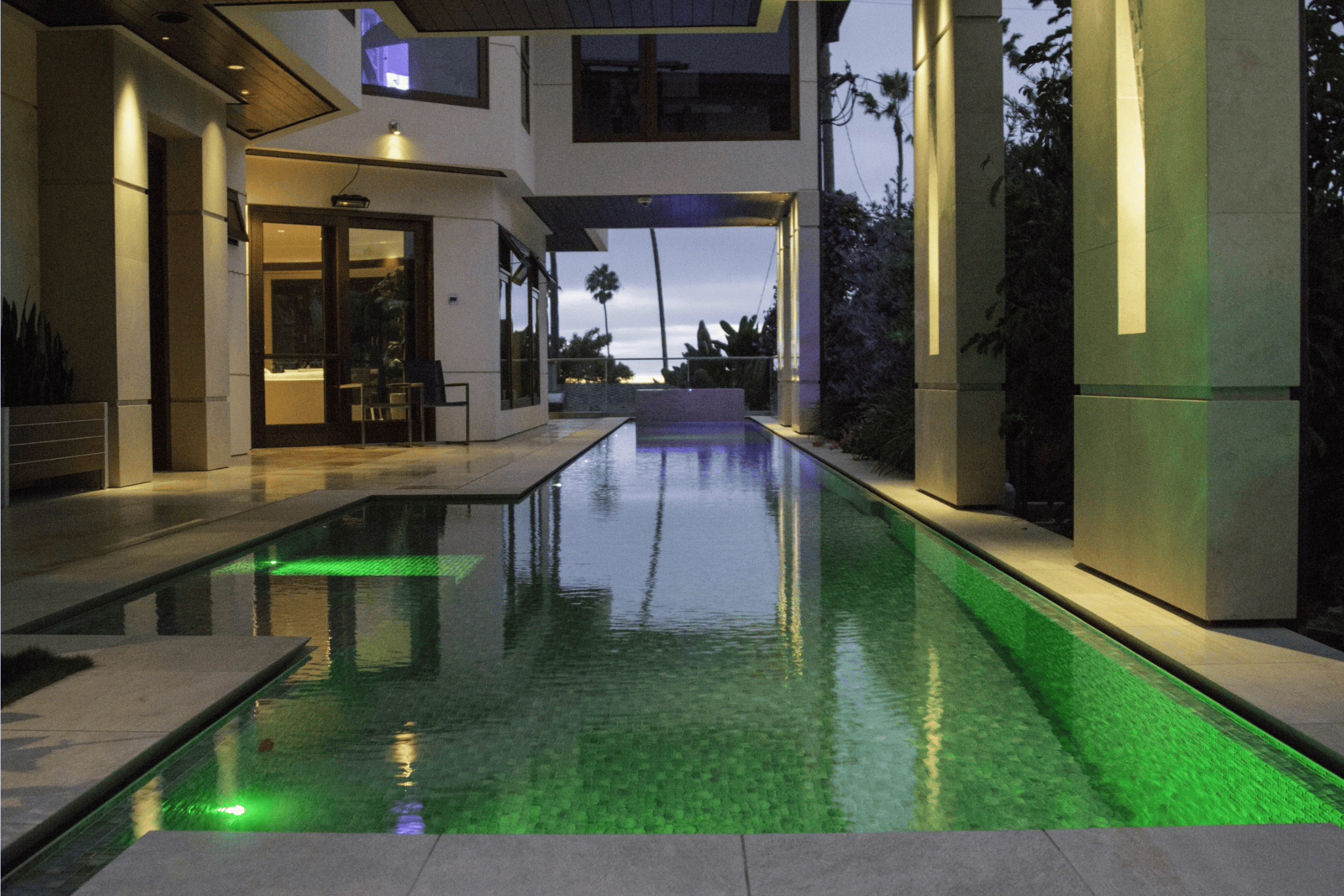 A luxury pool with green ambient lighting