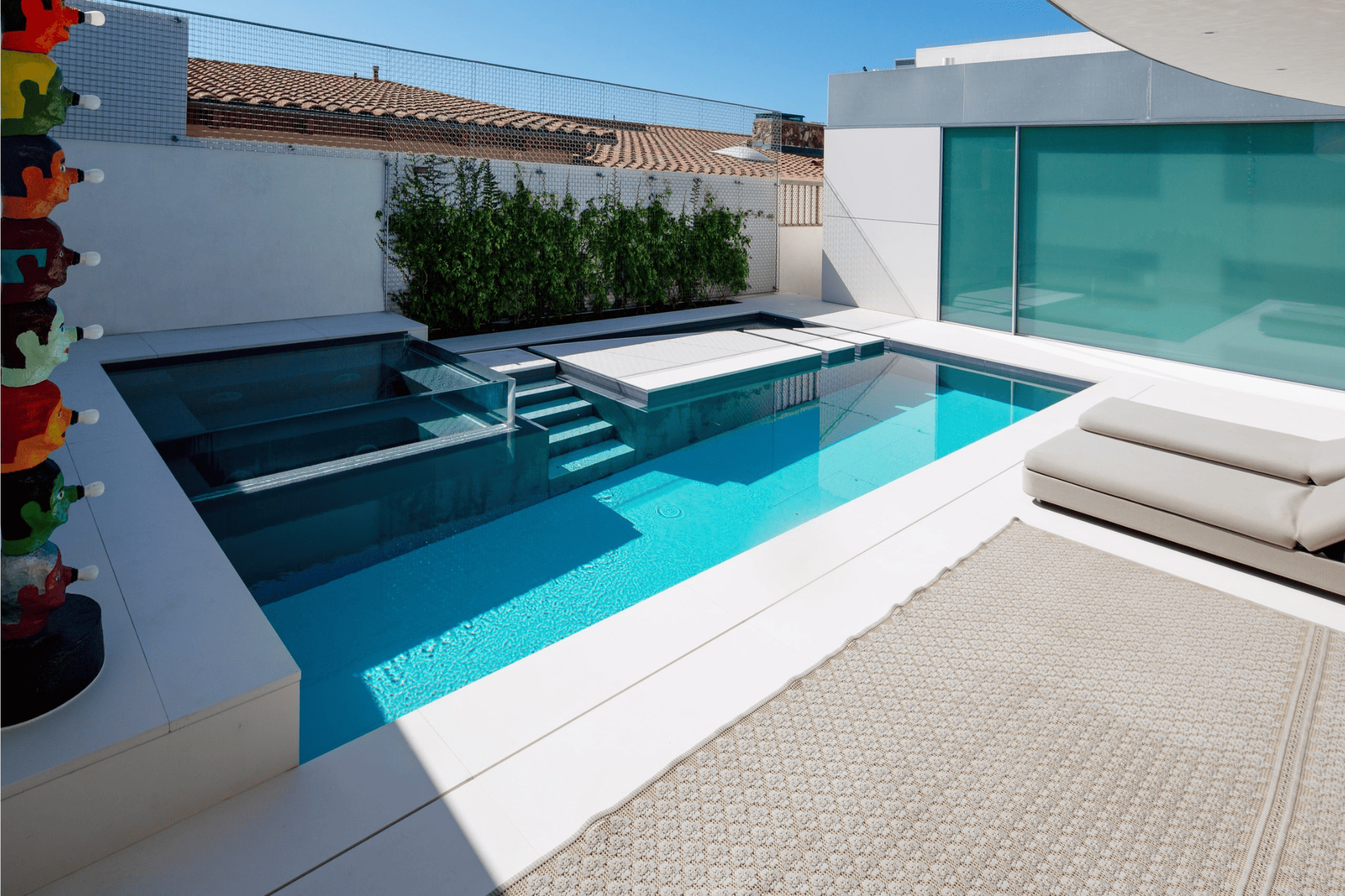 A luxury pool with tanning beds nearby in the daytime