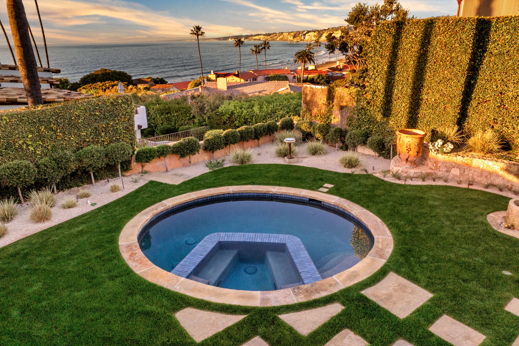 Round inground spa set in lawn with coastal ocean view