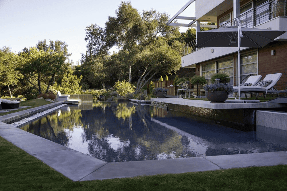 Long rectangular pool in hillside backyard setting