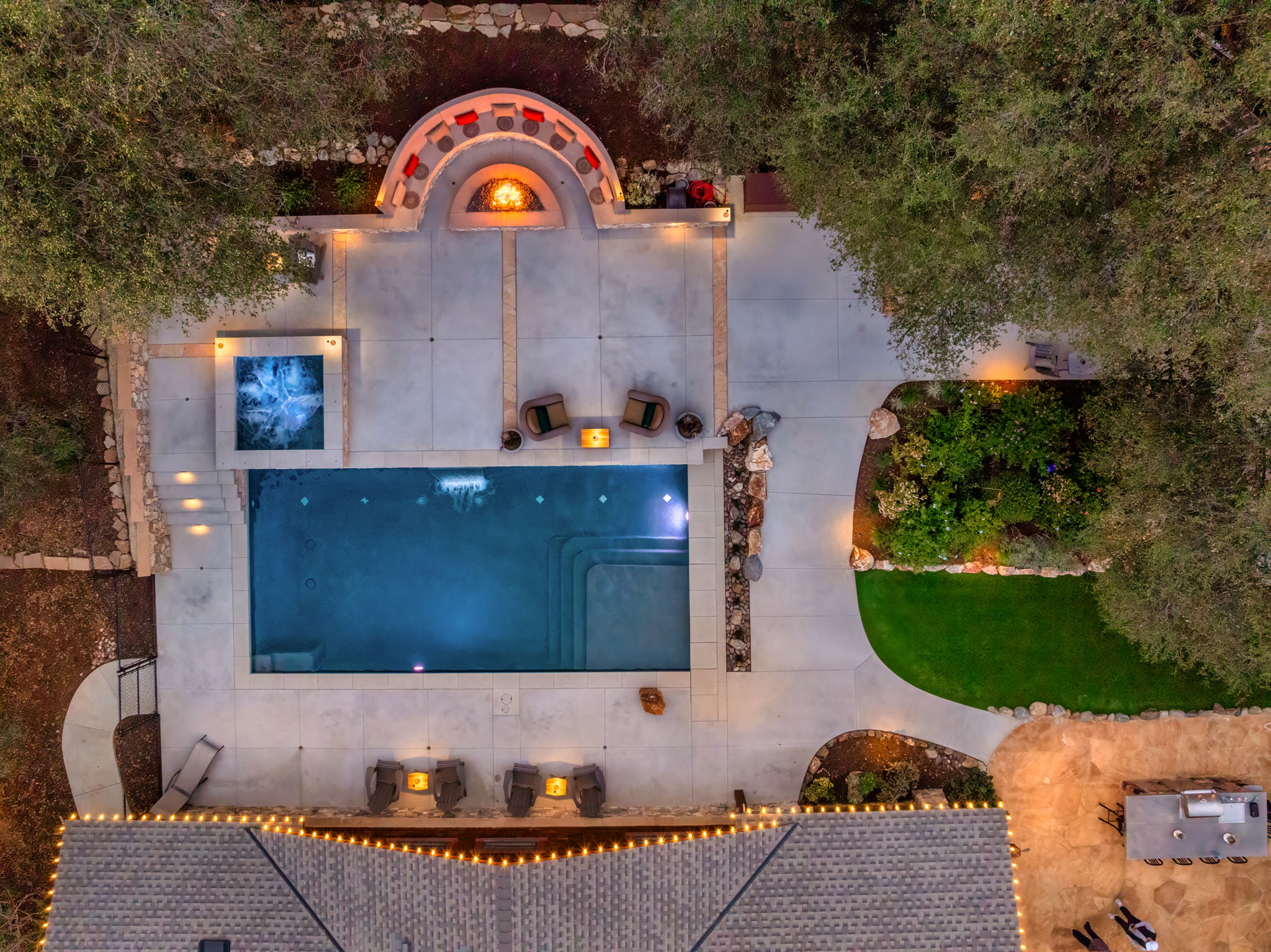Aerial view of luxury concrete pool with spa and fire pit