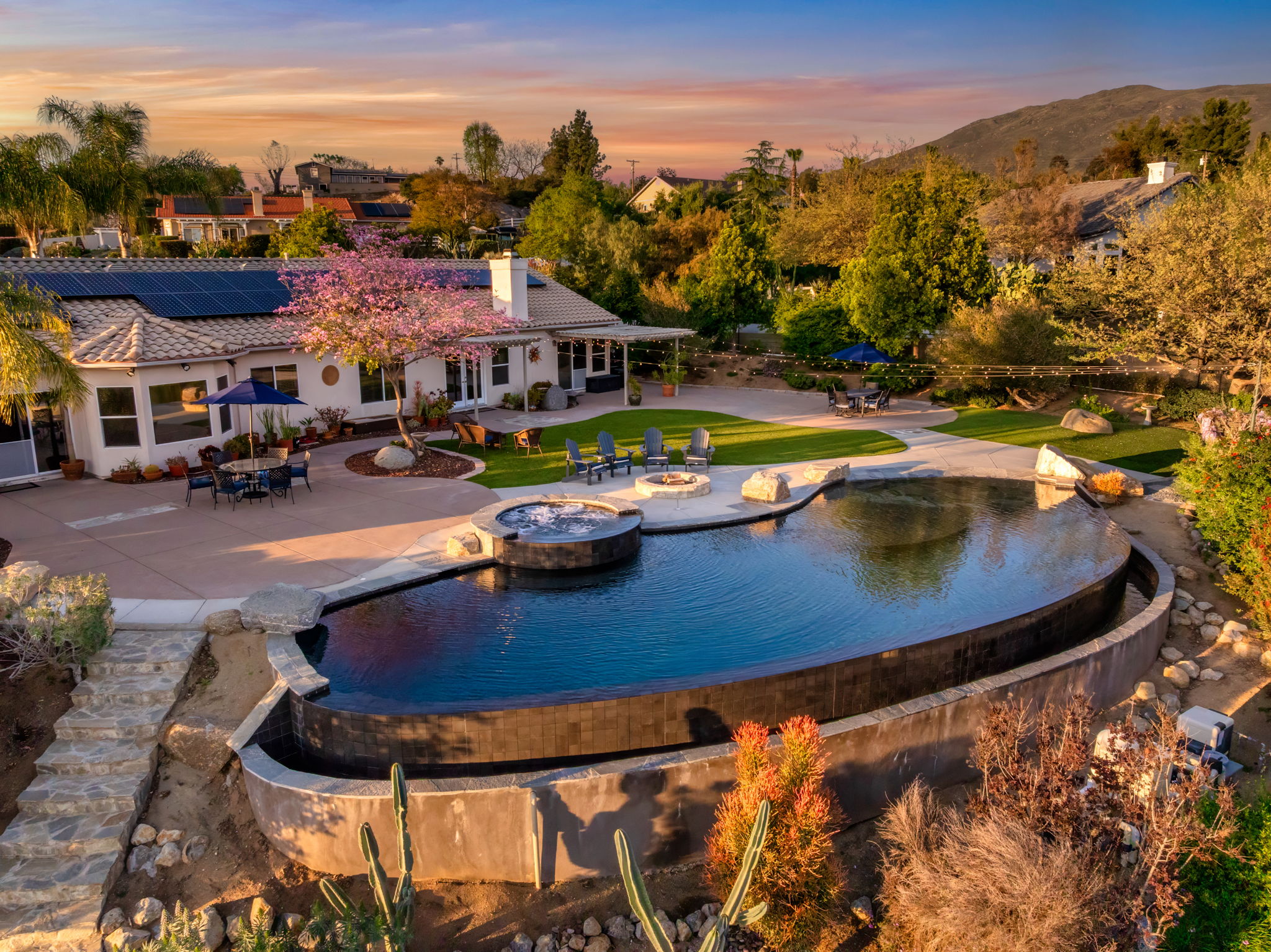 Infinity edge pool with spa and mountain views at sunset