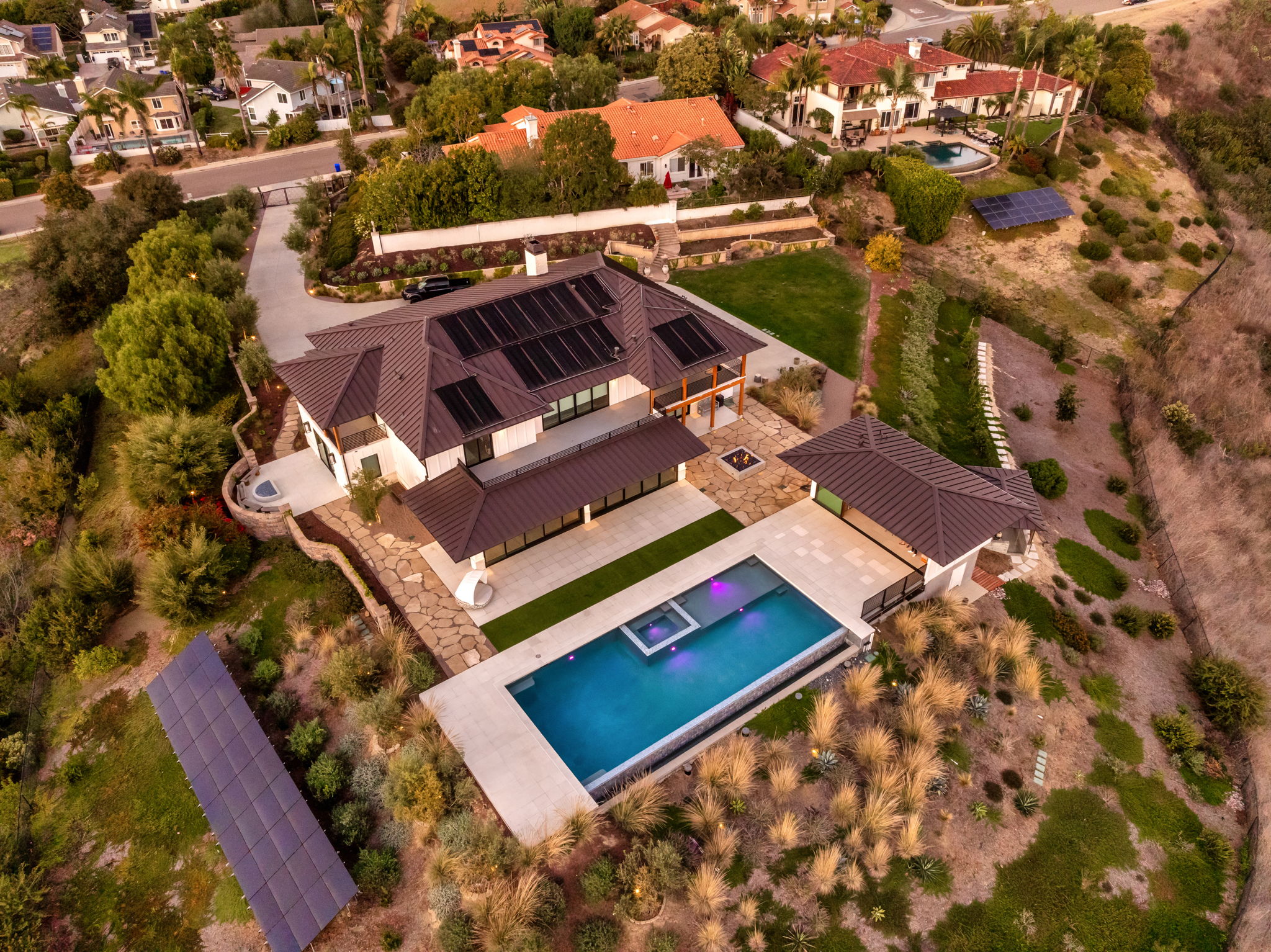 Aerial view of an inground pool installation on a hillside property, showing the full pool installation process result